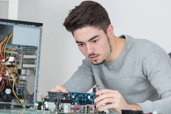 Junger, gutaussehender Computerreparateur konzentriert sich auf seine Arbeit — Stockfoto