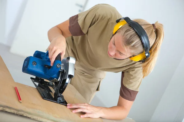 Kvinnlig arbetstagare använder jigsaw — Stockfoto