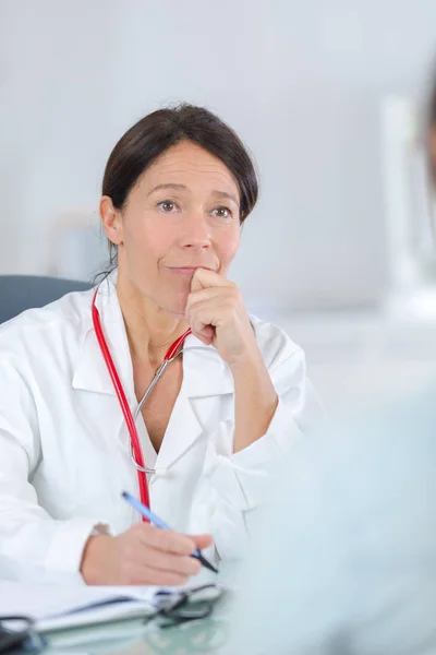 Женщина врач и пациент во время консультации — стоковое фото