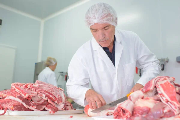 Macellaio che taglia la carne — Foto Stock