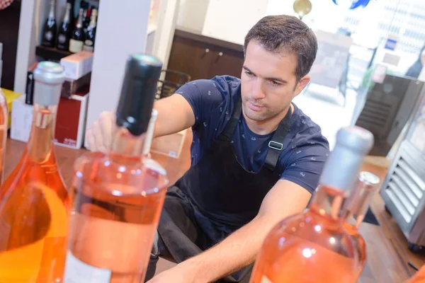 Trabajador apilando botellas de vino — Foto de Stock