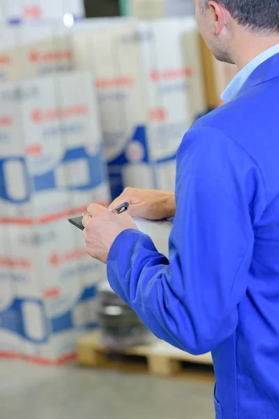 Warehouse worker making notes — Stock Photo, Image
