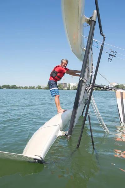 Salior tratando de enderezar su catamarán después de volcar — Foto de Stock