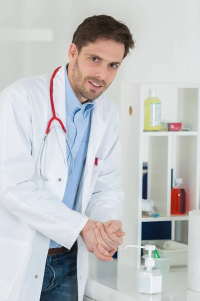 Arts met behulp van sanitizer dispenser in kliniek — Stockfoto
