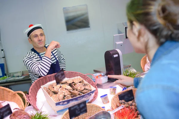 Bir Fransız şapkası giyen deniz ürünleri satıcı — Stok fotoğraf