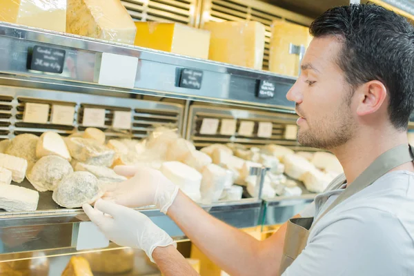 Hombre trabajando en una tienda de quesos —  Fotos de Stock
