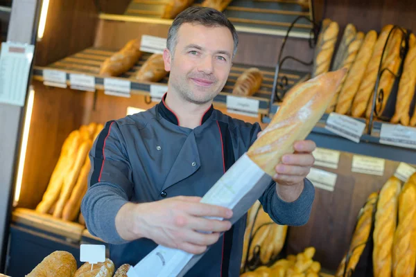 Panadería tendero está orgulloso de su producción de pan —  Fotos de Stock