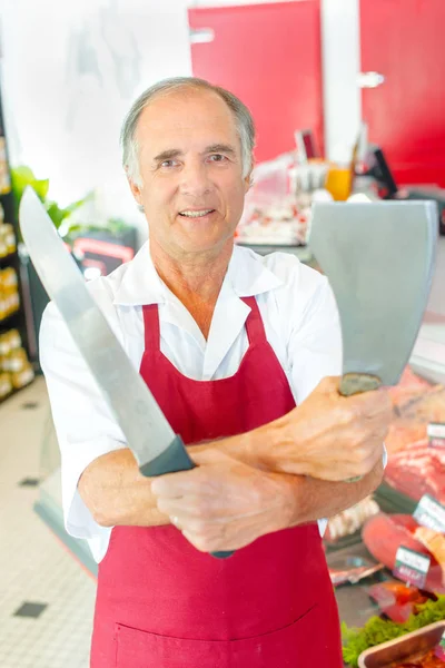 Metzger mit Machete in der einen Hand und langem Messer in der anderen — Stockfoto