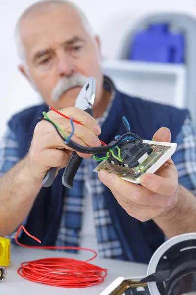 Eletricista trabalhando no dispositivo elétrico de parede — Fotografia de Stock