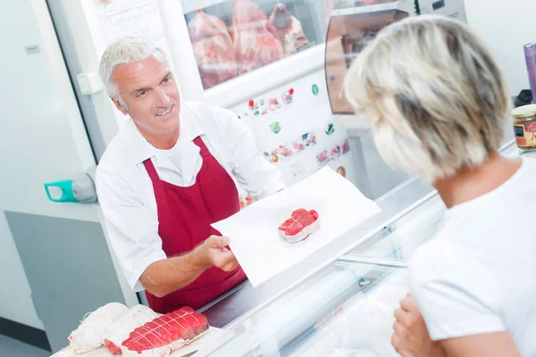 Butcher serving a client — Stock Photo, Image