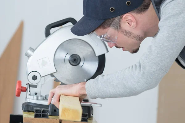 Carpenter cutting plank of wood with circular disc saw — Stock Photo, Image