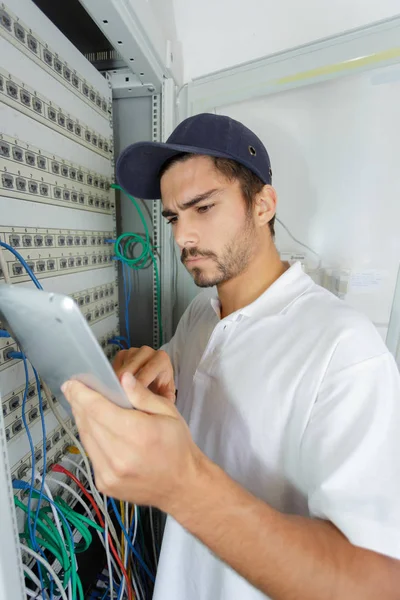 Elektryk koncentruje się stosowania procedury bezpieczeństwa podczas pracy na panelu elektrycznym — Zdjęcie stockowe