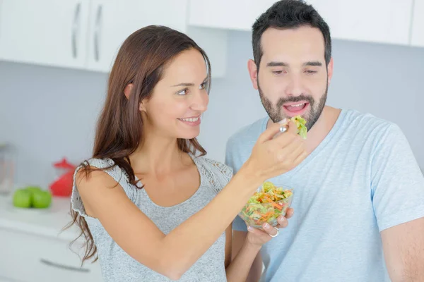 Casal feliz comer salada de legumes — Fotografia de Stock