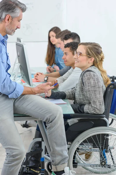 Enseignant avec étudiants, un handicapé — Photo