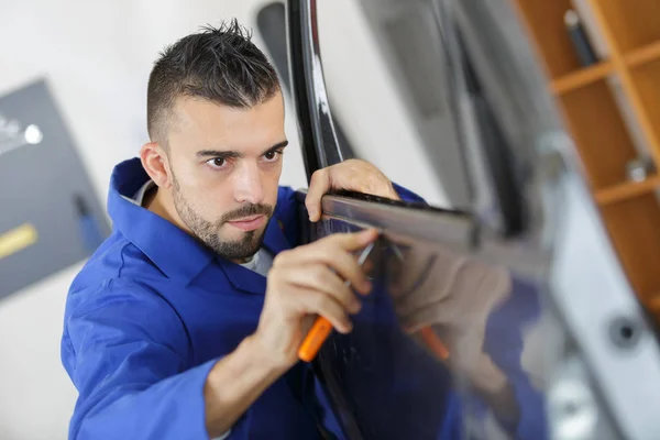 Man using screwdriver to fit door rubber — Stock Photo, Image