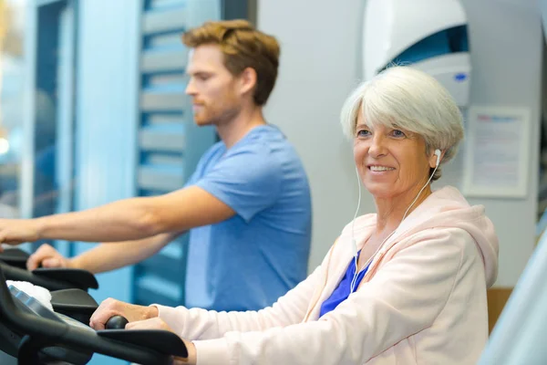 Oudere dame en jonge man met behulp van loopband — Stockfoto