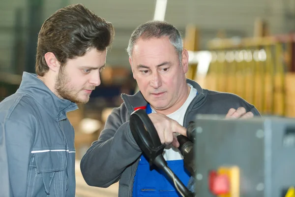 Junge Fabrikarbeiter lernen den Umgang mit Maschinen — Stockfoto