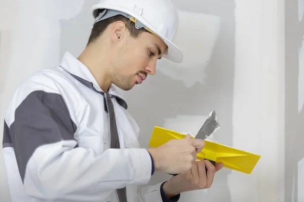 Bauarbeiter verputzt Zement an einer Wand — Stockfoto