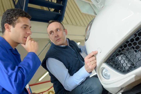 Mechanics looking at parking sensor on car — Stock Photo, Image