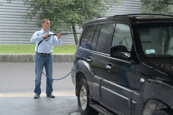 Man schoonmaken voertuig met hogedrukspuit — Stockfoto