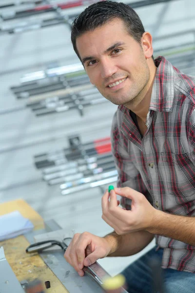 Hombre guapo usando una regla en un taller — Foto de Stock