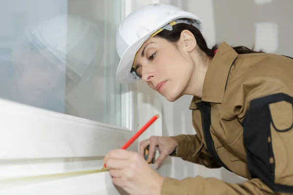 Kvinnliga byggarbetare installera nya windows — Stockfoto