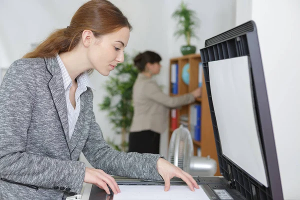 Uśmiecha się kobieta biznesu za pomocą kopiarka maszyny — Zdjęcie stockowe
