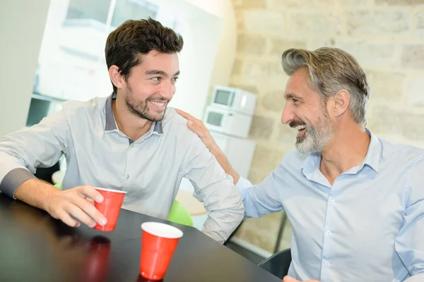 Män skrattar och dricker kaffe — Stockfoto