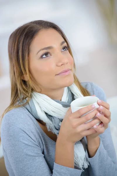 Šťastná mladá žena s šálkem čaje doma — Stock fotografie