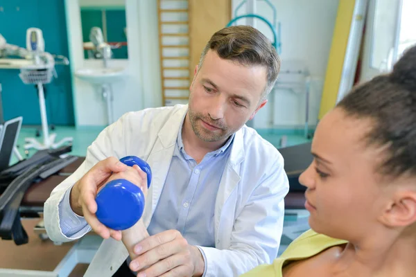 Therapeut doen arm oefeningen met halters voor verbetering van de arm kracht — Stockfoto