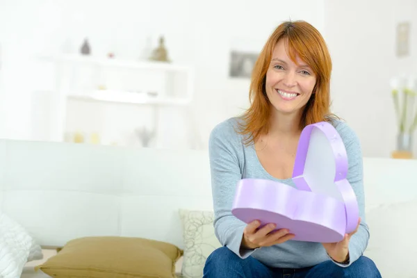 Frau mit Geschenk in herzförmiger Schachtel — Stockfoto