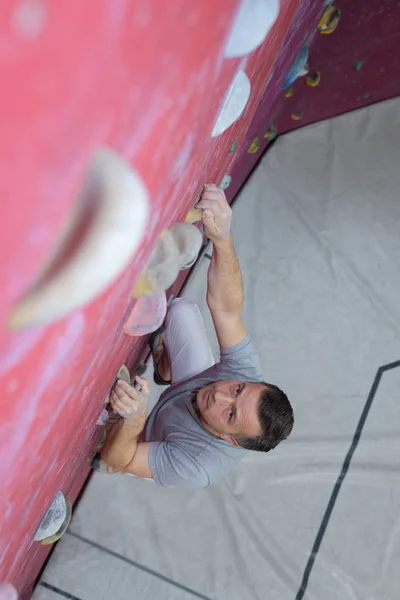 Homem na parede de escalada interior — Fotografia de Stock