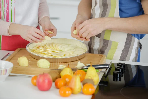 Handen van mensen voorbereiding appeltaart — Stockfoto