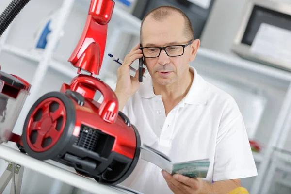 Repairman fixing vacuum cleaner — Stock Photo, Image