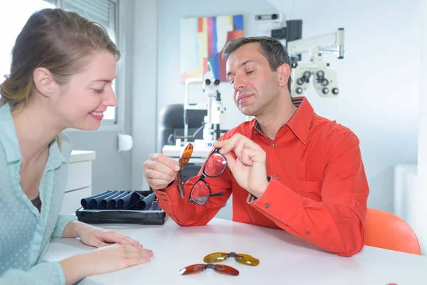 Pretty young woman choosing new glasses frames — Stock Photo, Image