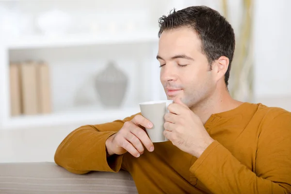 Расслабляться дома на диване и пить чай — стоковое фото