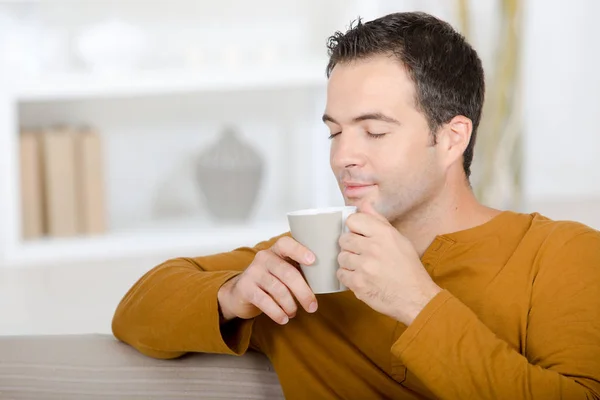 ソファの上に家でのんびりとお茶飲んで — ストック写真