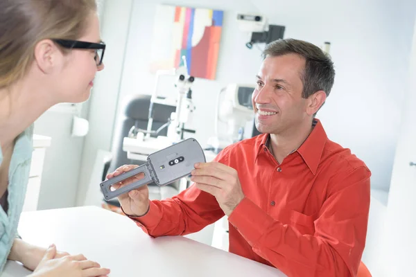 Optician with trial frame and patient at clinic — Stock Photo, Image