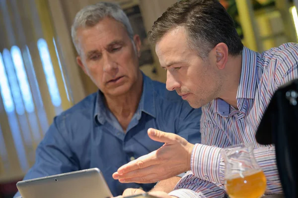 Men discussing information on tablet screen — Stock Photo, Image