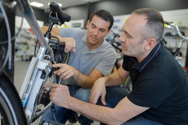 Mechaniker repariert batteriebetriebenes Fahrrad in seiner Werkstatt — Stockfoto