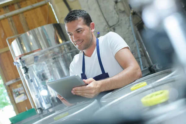 Cervejeiro confiante encomendar suprimentos em seu tablet — Fotografia de Stock