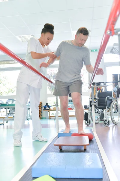 Physiotherapeut hilft Mann beim Gehen — Stockfoto