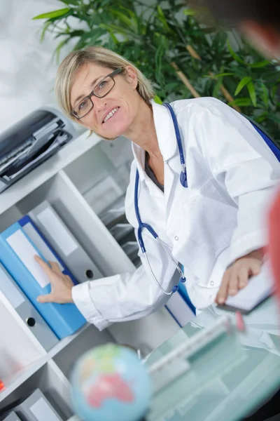 Portret van dokter nemen bestand van plank — Stockfoto