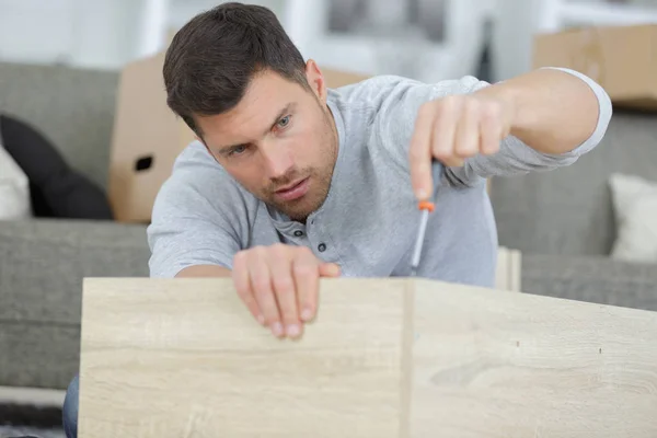 Homme en chemise assembler des meubles — Photo