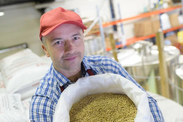 Lavoratore che mostra sacco di cereali — Foto Stock