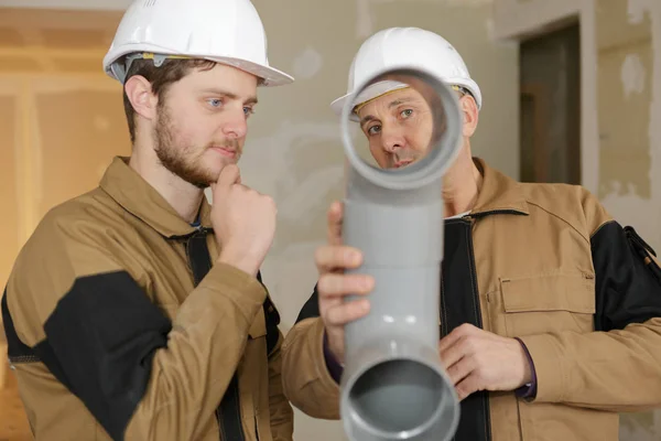 Encanador segurando um tubo de plástico — Fotografia de Stock