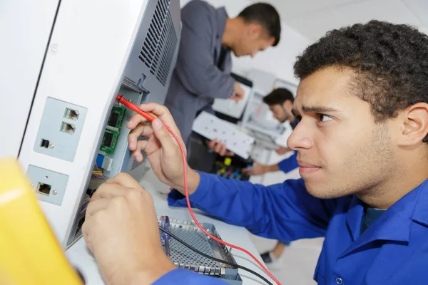 Studente accigliato utilizzando multimetro — Foto Stock