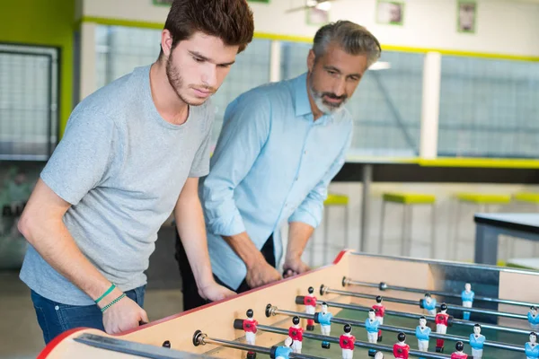 Vänner som har kul tillsammans spelar bordsfotboll — Stockfoto