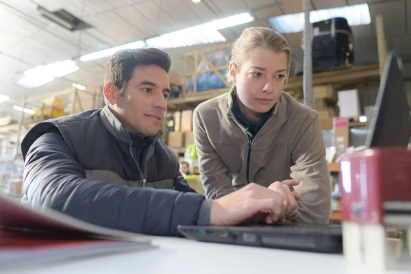 Warehouseman and female supervisor with laptop — Stock Photo, Image