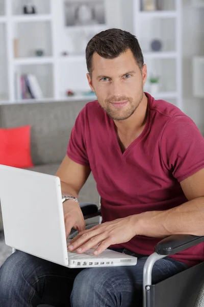 Портрет умного бизнесмена-инвалида, использующего ноутбук в помещении — стоковое фото